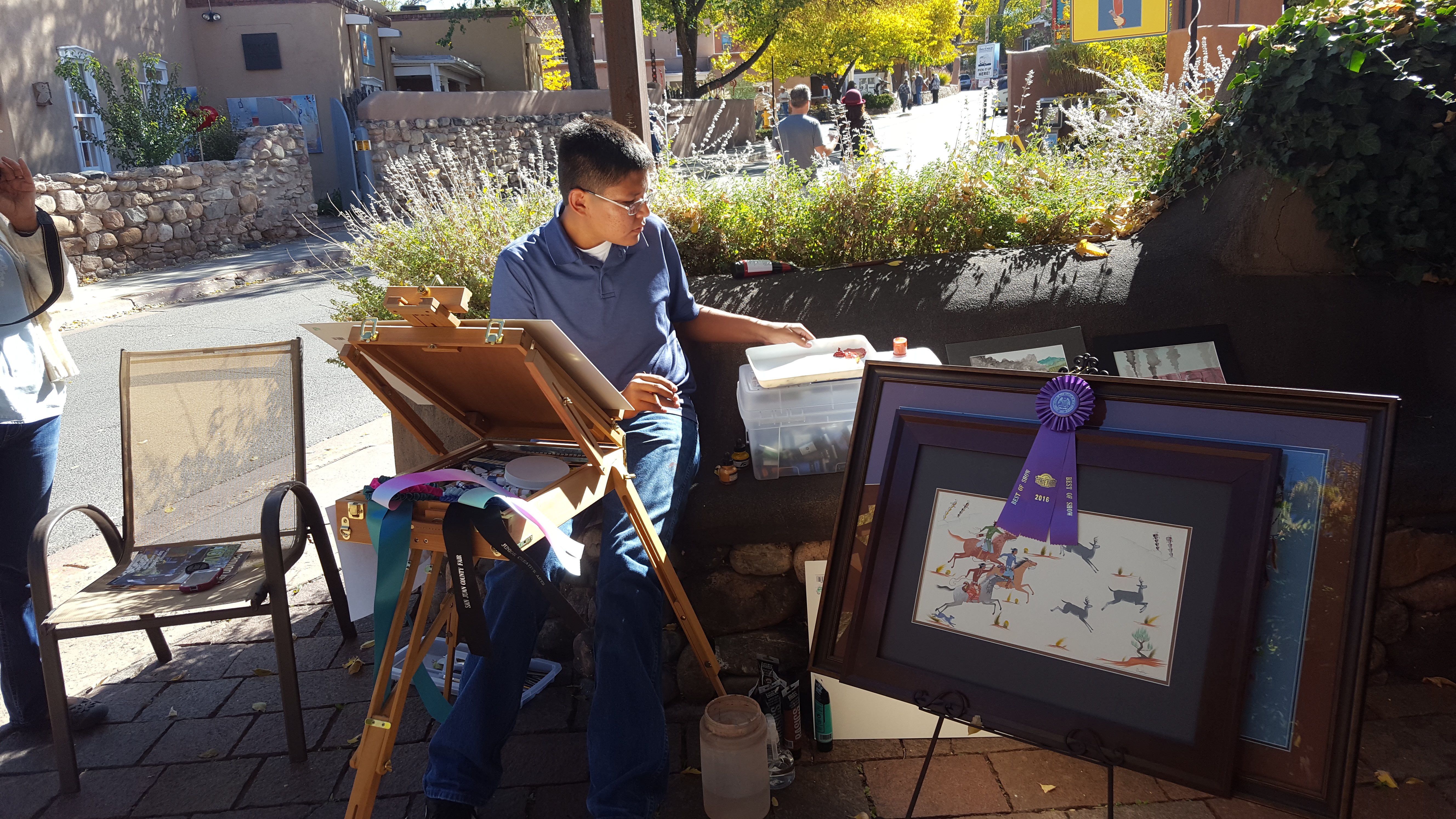 Myron Denetclaw (2000 - ) painting in front of Adobe Gallery during the Canyon Road Paint Out.