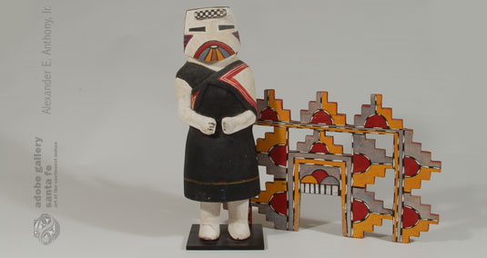 The tableta was made from crate wood, not plywood, another indication of the earlier age.  As is traditional, there are rain clouds and rain on her tableta and a rainbow on her chin.  She is wearing the traditional black manta with a shawl draped over her shoulders.  The tableta was made separately and slips into slots on the head of the doll.