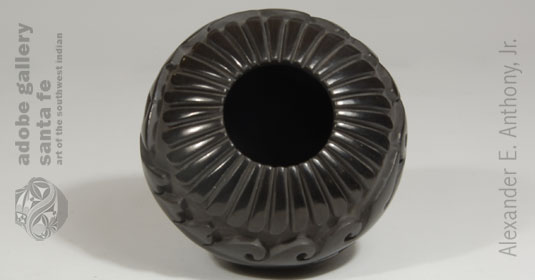 This stone-polished black jar, with 32 vertically-placed eagle feathers surrounding the rim, is typical of the intense amount of work she puts into each creation.  Each of these feathers necessitated polishing individually, leaving the valley between parallel feathers in a matte state. 