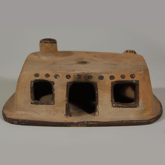 Pottery house structures such as this seem to have been popular in the early- to mid-20th century.  They were made by potters at several of the pueblos and were intended as inexpensive items to sell to tourists enchanted with New Mexico and its low adobe houses.  They have become quite collectible now.  It is difficult to place a date on most of them but probably mid-20th century or earlier is a good guess.   Condition: overall in excellent condition except that a small corner of the ground plane in the rear of the house broke off and has been glued back on and it truly is not noticeable. Provenance:  from a Santa Fe collector of pueblo pottery Recommended Reading:  Indian Arts and Crafts by Marjorie Miller