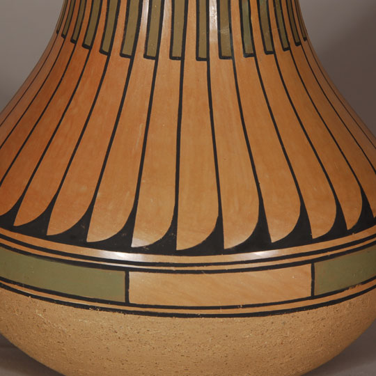 San Ildefonso Large Polychrome Jar Blue Corn and her husband, Sandy, spent two years in the 1960s experimenting with slips in an effort to revive the 19th century Polychrome wares of San Ildefonso Pueblo. She stone polished the base slip in the manner it was done before introduction of the Cochiti slip in 1905, which required only rag polishing. In doing this, she achieved a highly burnished finish. To this she applied the matte paint designs at which she was so adept. Blue Corn made redware and blackware during the earlier part of her career and specialized in polychrome wares during the latter part of her career. Most collectors prefer her polychrome wares. Normally, she applied a creamy white slip as the base coat, but in this jar, it appears she eliminated the slip and stone polished the natural clay. Over the polished surface, she painted the designs using black and green slips. The lower part of the vessel, below the design section, is slipped in beige micaceous clay. This jar is certainly one of her creative ventures that turned out to be successful. Condition: The jar is in original condition. There is one minor blister bubble and one very minor pit where probably a grain of sand popped out. Provenance: ex.coll. Minnesota pottery collector Recommended Reading: Pueblo Indian Pottery: 750 Artist Biographies, c.1800-Present