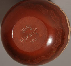 Jody Naranjo comes from a family of potters and educators. She began making pottery with her grandmother, Rose Naranjo, when she was eight years old. By the time she was a teenager she was creating prize-winning works of art.  Jody is an artist who weaves tradition and innovation in a most delightful way.  This little jar is a perfect example of her artistic talent. It incorporates the traditional method of hand coiling native clay and hand burnishing with a unique method of sgraffito to create a family of turtles swimming around the side.  The jar is signed and dated 2011 on the bottom.  Condition: This jar is new and in original excellent condition  Recommended Reading:  Pueblo Indian Pottery 750 Artist Biographies by Gregory Schaaf  Provenance: from the artist 