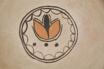 Elizabeth Trujillo has been actively making pottery since the 1970s.  Her large storage jar entered in competition at Santa Fe Indian Market in 1990 was judged the best pot.  In this stew bowl, Trujillo placed a “shield” design in the bottom of the interior and a display of butterflies and flowers on the exterior Condition:  There is no evidence that the bowl has ever been used.  It is in original condition.  Provenance: from the collection of Katherine H. Rust 