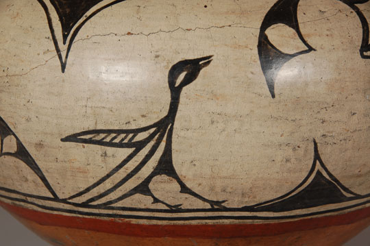 Martina Vigil Montoya (1856-1916) and Florentino Montoya (1858-1918) are considered to be among the best San Ildefonso potters of the late 19th century. This is a beautiful example of what we think is Martina&rsquo;s and Florentino&rsquo;s work, encompassing a great many of the characteristics for which their pottery is so well known and highly regarded.  Attributing work to long-deceased artists is always subject to questions, but sometimes the work just seems to fit the hands of certain artists and it is not wrong to speculate that it was made by them.  That is the case with this San Ildefonso jar.  It has design elements that have been associated with Martina and Florentino.  Jonathan Batkin, in an article in American Indian Art Magazine in 1987 illustrated a number of vessels by this famous couple and there are designs in those that are easily recognizable in this jar.  The kite-like elements suspended from the framing line at the shoulder are illustrated in several of the published pots.   The cresting wave-like elements around the neck that have white centers are easily recognizable as neck decorations in some of the published pots.   This jar has the Cochiti slip that is known to have been used by Marina and Florentino.    Similar pictorial elements like the two birds and the human-like figures do not appear on any of the published pottery by this famous couple but that does not preclude them having made this jar.  We feel that there are sufficient similarities to known examples of their pottery to attribute this jar to their hands.  Condition:  There is a lateral and vertical crack on one side of the jar both of which have been stabilized with glue without any plaster fill or over-paint.  The jar is in stable condition without any restoration, only stabilization.  There is one small pin-head size hole.  Provenance: from an Albuquerque gentleman.  Recommended Reading:  Batkin, Jonathan. &ldquo; Martina Vigil and Florentino Montoya: Master Potters of San Ildefonso and Cochiti Pueblos.&rdquo; American Indian Art Magazine, vol. 12, Number 4, autumn 1987, pp. 28-37. 