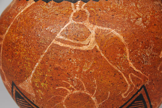 “Ralph Aragon was born at San Felipe, but married into Zia Pueblo.  He is credited with creating a new style of painting Pueblo pottery.  His designs employ a wide array of symbols, sometimes drawing from ancient rock art.  He also uses a spatter technique reminiscent of Joe Herrera and Tony Da, two contemporaries of modern styles.  “Ralph transcends his success as an easel painter by also painting pottery in his own unique way.  His pots are easily recognizable.  He uses bold colors and ancient designs to create fine art pieces that look both ancient and modern simultaneously.  He is a true artist in his constant innovations, developing a myriad of variations on Southwest Indian pottery.”  Schaaf, 2002  This fine jar features several petroglyph-style animal and human figures.  There is a female carrying an olla on her head, a flute player, and several birds and animals.  Condition:  the jar is in original condition.  Provenance: from the collection of Katherine H. Rust  Recommended Reading:  Southern Pueblo Pottery: 2000 Artist Biographies by Gregory Schaaf 