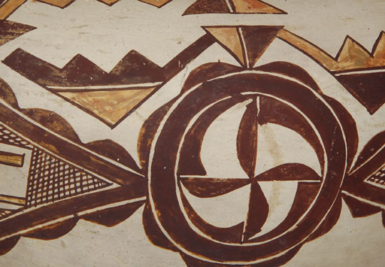 Early in the 20th century, as an inducement to tourists, potters from most of the pueblos adopted vessel forms not traditional to their pueblos.  The depression era was affecting their sales and they were eager to make what they felt would appeal to the few travelers who were venturing to the pueblos.  The early ones were traditional in size and design with only minor vessel shape changes.    This jar, with the restricted neck, fluted rim, and a pair of strap handles is one of the vessel shapes that Acoma potters made in an attempt to appeal to tourists.  The neck is too restrictive to permit use of a gourd ladle and the pair of handles is non-functional for lifting a jar full of water.  These changes to traditional Acoma water jars, although minor, were believed to appeal to buyers who might not like the traditional olla shape used by the pueblo homeowner.    This early period of catering to the desires of travelers was a period where the quality of pottery was still high but it was followed later in the century by a decline in quality when potters started making ashtrays, trinkets and knickknacks.    The quality of this jar is equal to that being made previously.  Only the shape was a compromise and it was not a bad change at all.  It provided variety to the previously-made standardized vessel shape of water jars.  Also, designs on these early 20th century jars continued to be creative and well executed—equal to that being applied to late 19th century vessels.  Condition:  excellent condition for a jar approaching an age of 100 years.  Provenance: from an Albuquerque gentleman  Recommended Reading: Acoma and Laguna Pottery by Rick Dillingham 