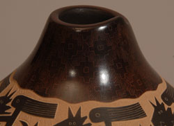 Jody Naranjo is a prize-winning potter from Santa Clara Pueblo who has taken the art form of pueblo pottery to a brand new level. She has been awarded prizes since she was a teen.  She comes from a family of prize-winning potters and artists.   While continuing the tradition of hand coiling and hand polishing pottery as done by her ancestors she brings a totally contemporary vibrancy to her work.  She began making pottery with her grandmother, Rose Naranjo, when she was eight years old. By the time she was a teenager she was creating prize-winning works of art.  Jody is an artist who weaves tradition and innovation in a most delightful way.  This little jar is a perfect example of her artistic talent. It incorporates the traditional method of hand coiling native clay and hand burnishing with a unique method of sgraffito to create a panoramic design of Indians on horses which she has named &ldquo;Crazy Horse.&rdquo;  It is difficult to see in these photographs, but around the neck and base of the jar, the artist has inscribed designs that literally appear to be under the surface of the clay.    Condition: original condition  Provenance: from an Albuquerque gentleman  Recommended Reading: Pueblo Indian Pottery: 750 Artist Biographies by Gregory Schaaf 
