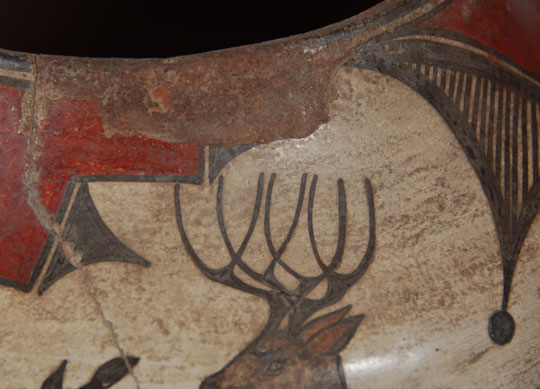 Turn-of-the-century pottery from Zia Pueblo displays a deep red color to the slip as well as very deep brown mineral-based pigment used in the designs.  These deep wonderful colors disappeared in post- 1900 pottery and the red became more tomato soup color and the brown a weaker tint.  According to Harlow and Lanmon, &ldquo;There are discernible changes in the character and physical characteristics of the red and black pigments that further assist us in dating individual vessels.&rdquo;  The black pigment was generally browner in coloration until 1850 and then tended to become darker after that.  By 1900, the black appears to be dark strong brown.  The red pigments varied from deep red to orange-red to brick-red but by 1900 the red tended to be dark in coloration.  It is based on the beautiful dark red and strong brown pigments in this jar that we have selected a date of 1890 to 1910 as the most probable period in which it was made.  It was during this period also that some pottery began to be associated with particular makers by name.  A couple of potters of this period who made jars of the high quality of this one are Isabel Medina Toribio and Trinidad Gachupin Medina.  We are not making an attribution to either of these potters but mention them as possibly responsible.  The brown pigment in the floral elements on this jar is very thick and rich in color.  The brown pigment on the deer was applied in lighter tint.  The red band on the lower underbody that separates the cream slip from the polished red underbody is another indication for dating pottery of the circa 1900 period.  Before 1910, the red band is distinguishable from the polished underbody but that distinction begins to disappear after 1910.  The red band on this jar is quite distinguishable, an indication that the jar pre-dates 1910.  There is a deep concave bottom to the jar.  Condition:  overall the jar is in very good condition for its age.  There are indications that the jar was used for its intended purpose.  There are a couple cracks that have been stabilized and there is slip loss near the rim resulting from overflow of water while in use.  Provenance:  from the collection of a gentleman in Colorado  Recommended Reading: The Pottery of Zia Pueblo by Francis H. Harlow and Dwight P. Lanmon 