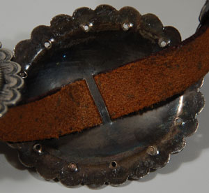 The Navajo (Diné) are a people who have added much beauty to their world and ours. Beauty is a quality they particularly appreciate; it is a repeated theme in their songs, ceremonies and in their rugs and jewelry.   This Navajo sterling silver concha belt is comprised of 9 oval conchas and a rectangular buckle.  Each concha has a cutout at its center in the style of the 19th century “first phase” conchas, a style revived in the 1950s or a little earlier.  The style that followed this one eliminated the cutout and replaced it with a loop on the underside through which the belt could be attached.  The edges of the conchas are scalloped and stamped with traditional silver stamps.  The buckle is repoussé.    Condition:  the silver has just recently been polished which removed decades of patina but that will re-appear in time.  There are a few scratches but nothing of significance.  The belt is ready to wear.  Provenance: from a collector in Indiana who purchased it at the Bright Angel Lodge at the Grand Canyon in early 1950s  Recommended Reading:  Indian Silver Jewelry of the Southwest: 1868-1930 by Larry Frank, et al. 