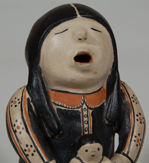 What is known today as a Storyteller figurine had its beginning in 1964 from the hands of Cochiti Pueblo potter Helen Cordero.  Alexander Girard, the noted architect and folk art collector, saw a figurine by Cordero at a Santo Domingo feast day arts and crafts booth and requested that she make more and larger ones and bring them to him.  He continued to encourage her to make larger ones with more children.  When Cordero began thinking about his requests, she made a male storyteller with several children based on her remembering that her grandfather was a storyteller at the pueblo. Her creation, based on her grandfather, was the beginning of the storyteller figurine tradition at Cochiti Pueblo.  In the almost five decades since her creation, the storyteller figurine tradition has blossomed.    Today, many potters at almost all the pueblos make figurines, some male and some female, but Cordero continued only making male storytellers because of the connection to her grandfather.  She never made a female storyteller. Her female figurines are called other names, such as Singing Mother, Hopi Maiden or other names. Cordero used to say that the potters who made female figurines and called them storytellers didn't understand her intent.  This figurine is a testament to Cordero's talent. It is beautifully sculpted and painted. The single child sitting in the adult’s lap has his hands crossed over his chest as he stares down at his dog who is sitting on the leg of the adult. The adult’s shirt is beautifully designed and decorated.  His hair hangs down in braids over his shoulders.  He wears the old traditional white cotton pants and cow hide moccasins.  Condition: original condition Provenance:  Adobe Gallery sold this figurine to the current owners in 1999 and they have now brought it back to us to sell for them. Recommended Reading:  The Pueblo Storyteller: Development of a Figurative Ceramic Tradition by Barbara Babcock. 