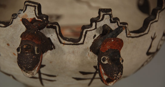 Vessels such as this Zuni bowl suggest use in ceremonial functions but most likely that has not occurred. It is more likely that such were made solely to sell to tourists.  Zuni elders would not have permitted ceremonial vessels to leave the pueblo and be sold.   An interesting story will illustrate the events that dealers would go to in order to sell pottery, and probably other Native items, in the early 1900s.  Museums were eager to acquire ceremonial objects which, of course, were not generally available unless someone from the pueblo sold something without permission to do so.   Because of the desire by museums in the Santa Fe area, the trader at Zuni in the early 1900s seems to have dreamed up a scheme to "find" a cache of Zuni ceremonial pottery jars and sell them to the Laboratory of Anthropology in Santa Fe.  Around 1920, a large group of Zuni ceremonial vessels supposedly were available from Zuni and the trader made a deal to sell them to the Lab.  There were around 260 of them.  The Lab director convinced John D. Rockefeller of New York, who had earlier funded the building for the Lab, to purchase this important and secret collection for a sum of around $10,000, which was a very large amount at the time when jars were selling for maybe $1 or slightly more.   Because the transaction was a hushed-up affair, the cache of jars was stored in a vault at the Lab where they stayed for over 75 years.  When Dr. Bruce Bernstein was director of the Museum of Indian Arts and Culture, he became interested in the collection and spent the next 20 years studying them and getting advice from Zuni elders who declared they were not ceremonial in any manner.  This was a hoax that was clothed in secrecy and ultimately uncovered.  The Zuni were probably innocent of the charade.  Potters most likely received orders for ceremonial-like vessels and made them by the trader's specification and sold them without knowing they were being sold as historic.   This Zuni bowl we are featuring today is not of the style of the ones at the Lab but is a style based on ceremonial vessels used by the Zuni, but, unless a vessel has been used in ceremonial fashion, it is not ceremonial even if it is of the same style.  The use of water creatures—in this case frogs, dragonflies, tadpoles, and plumed serpents—is standard fare on ceremonial vessels, so this bowl could be labeled "pseudo-ceremonial" if one wished to do so.  The plumed serpent is known as Kolowisi at Zuni and is an important water creature.  Kolowisi is a hero to the Zuni because he saved them from a flood and provided sustenance to them at the time.  After the flood, he stayed at the pueblo and resides underground in a lake.  He can and does appear in irrigation acequias and the Zuni River or any other body of water and serves as a guardian of water sources.   This bowl has 7 terraces around the rim and a footed base, elements generally not used except on ceremonial bowls.  On the exterior of the bowl are five frogs and two dragonflies painted in brown as is the rim of the bowl.  On the interior are five tadpoles and a frog also painted in brown.  The bodies of a pair of Kolowisi are raised on the clay body and painted in brown and red and outlined in brown.  The heads of the serpents penetrate the bowl and hang on the exterior.  Their heads are brown and the plumes are red.   The bowl evokes an element of mystique and makes one think it is an item used in a secret fashion in some ceremony in a kiva not witnessed by anyone other than high priests or important persons.  It feeds that need in us to feel we have discovered something that is rare and wonderful, which, in reality, is true.  These are rare and wonderful and one is fortunate to be able to add one to a collection.   Condition: original condition Provenance: from a family in Santa Fe Recommended Reading: The Pottery of Zuni Pueblo by Francis Harlow and Dwight Lanmon