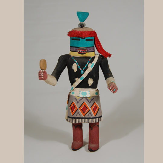 The Hopi have katsinam that honor and depict other tribes that are their neighbors, among them, the Navajo (Diné). This male version of Tasavkatsinam (Tasaf, Tasap) is in honor of their near neighboring tribe, the Diné. Katsina of this style are not borrowed from other tribes but are in honor of the other tribes. They are Hopi Katsina in all respects and are accorded the same reverence and honor as any other katsina. Their function, as is the function of all Hopi katsina, is to serve the Hopi as messengers to the rain gods.   This carving by an unknown Hopi carver probably dates to circa 1950s.  He features an elegant arrangement of red hair made from fine red yarn.  The bandoleer across his chest is made from deer hide as is the concha belt and the ketoh on his left wrist.    Condition:  He had cotton glued to the four white spots on his chest and back and the white spot on each of his arms but most of the cotton is missing.  He carries a gourd rattle in his right hand but whatever he might have had in his left hand is missing as are the feathers on the right side of the mask. There is a faint crack in the paint behind the right shoulder but it is not significant. Provenance: from the estate of Michael Frost of Texas Recommended Reading:  Kachinas: a Hopi Artist's Documentary by Barton Wright