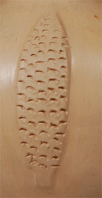 close up view of bas relief element of ears of corn on this jar