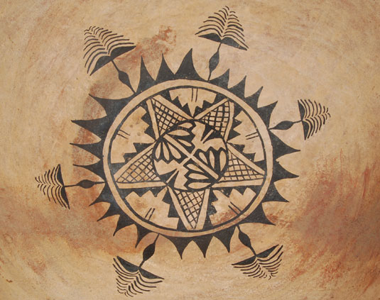 close up view: The interior design is a beautiful circular pattern of sun flower shape with radiating rays and floral elements expanding outward.  