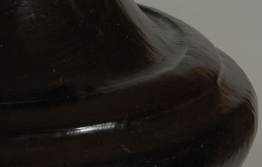 The one-inch wide band of clay just above the mid-body has resulted in defining the area as a double-shoulder.  This was an innovation of Sara Fina and is most often seen on her jars of this style.  