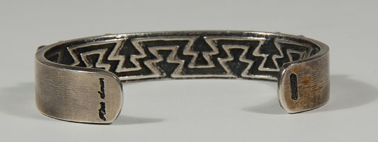 In this bracelet, he concealed the design on the inside of the silver, which features a pair of zigzag lines locked within each other.  