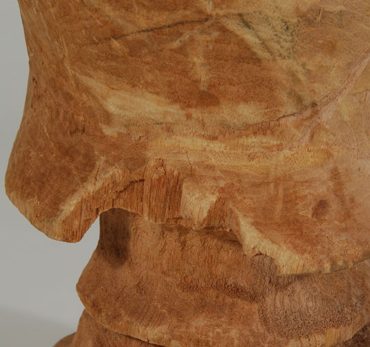 During carving, a section of the cape on the back side broke off so the carver abandoned the work.  