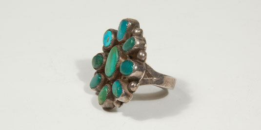 This cluster ring has eight high grade turquoise stones surrounding a larger middle stone. The depth and color of the stones are the focal points of the ring. 