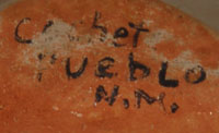 This storyteller is signed on the bottom Cochet Pueblo N.M. in what appears to be paint before firing. 