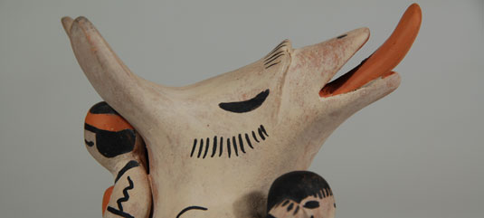 Close up: This figurine is of a coyote holding human children - check out the tongue!
