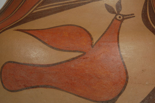 Close up view of the side panel design: The three Zia birds on this jar are of the same style—each with simple tail feathers, a single wing feather, and a crown on the head. The intriguing aspect of the design is the rainbow arcs as they are bands rather than arcs.  The simplicity of the design is another indication of an early date for the jar.
