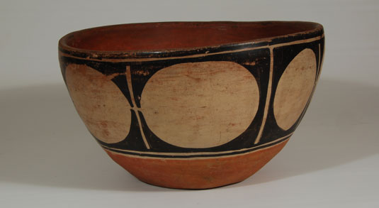 The most prominent designs associated with Santo Domingo Pueblo are black triangles that form a star pattern and the cream ovals outlined in black squares. This deep bowl has the large cream ovals or circles outlined in black that are so tied to its name.