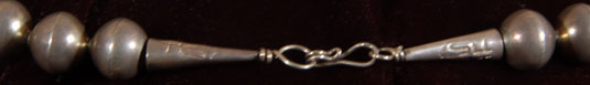 The necklace has silver cones at each end and each of the cones has a saguaro cactus stamped into the silver.  