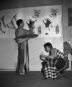 Image of Ignacio Moquino painting mural for the U.S. Office of Indian Affairs at the Exposition, 1939. Unknown Source.  Original caption: 01/07/1939-SAN FRANCISCO, CA: Joe Evans Duran (RT) and Ignacio Moquino (LT) working on murals for the Indian room of the new Federal ...