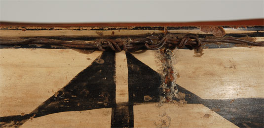 Native repairs on a pottery vessel is an indication of its importance to the owner as an item with which she would have need for household use.  Minor cracks can be stabilized on a dough bowl such as this one by wrapping a wire or rawhide around the rim as a cinch.  Additionally, the crack or cracks can be covered in piñon pitch as a sealant to prevent eventual chipping and worsening of the crack.  This bowl has both remedies.  There is wire wrapped around the bowl just under the rolled-out rim and it has an elaborate hooking tie.  There are remnants of piñon pitch over three vertical rim cracks.  Most of the piñon has fallen off but enough remains to identify it.