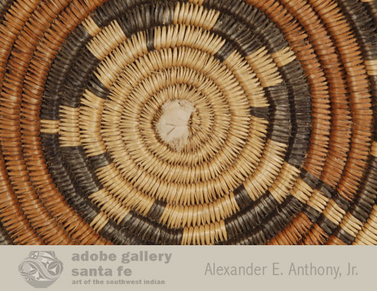 Close up view of this basket. When there is a piece of fabric stuffed in the hole in the beginning of a Navajo basket, that is an indication that the basket was used in a ceremony where sacred corn meal or soap suds was in the basket.  The fabric presents the contents from falling through the hole.