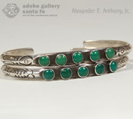 This bracelet was brought to us along with a pair of single-row bracelets (our Item # C4018A - click here to view) of the same vintage and same shade of green turquoise.  Those two traditionally served as guards for this one.