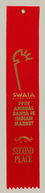 This small jar, a little over 2 x 2 inches, was made in the year 2000 and entered in competition at Santa Fe Indian Market that year.  The current owners purchased it directly from the artist at that year’s Indian Market.  It had been awarded a Second-Place ribbon by judges, Bob Andrews. Charles King, and Jody Folwell.