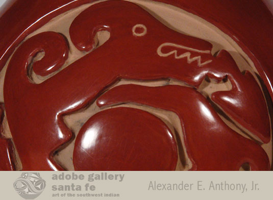 The design chosen by the artist is the revered Avanyu.  He is curled around a central circle with his tail tucked under his chin.  Lightning fires from his mouth in the guise of an arrow.  The design was repeated on front and back of the canteen.